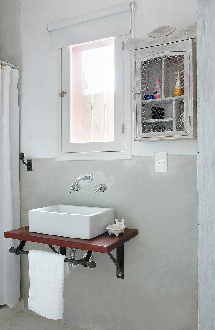 Wall mounted washstand and cabinet at bathroom window