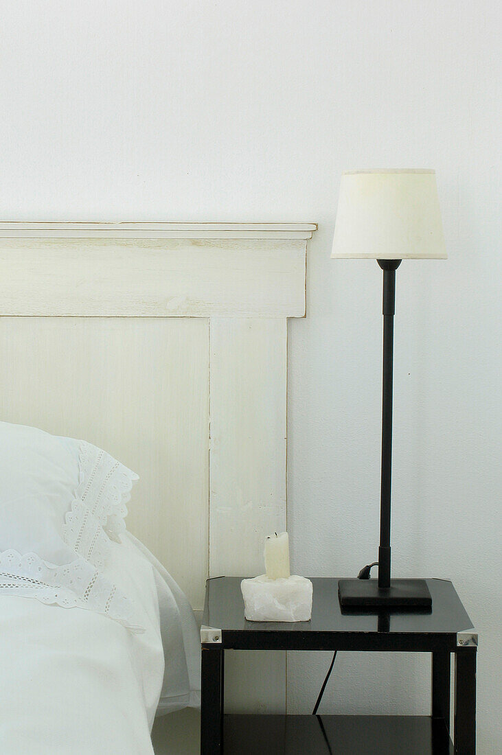 Headboard in guest room with lamp on low table