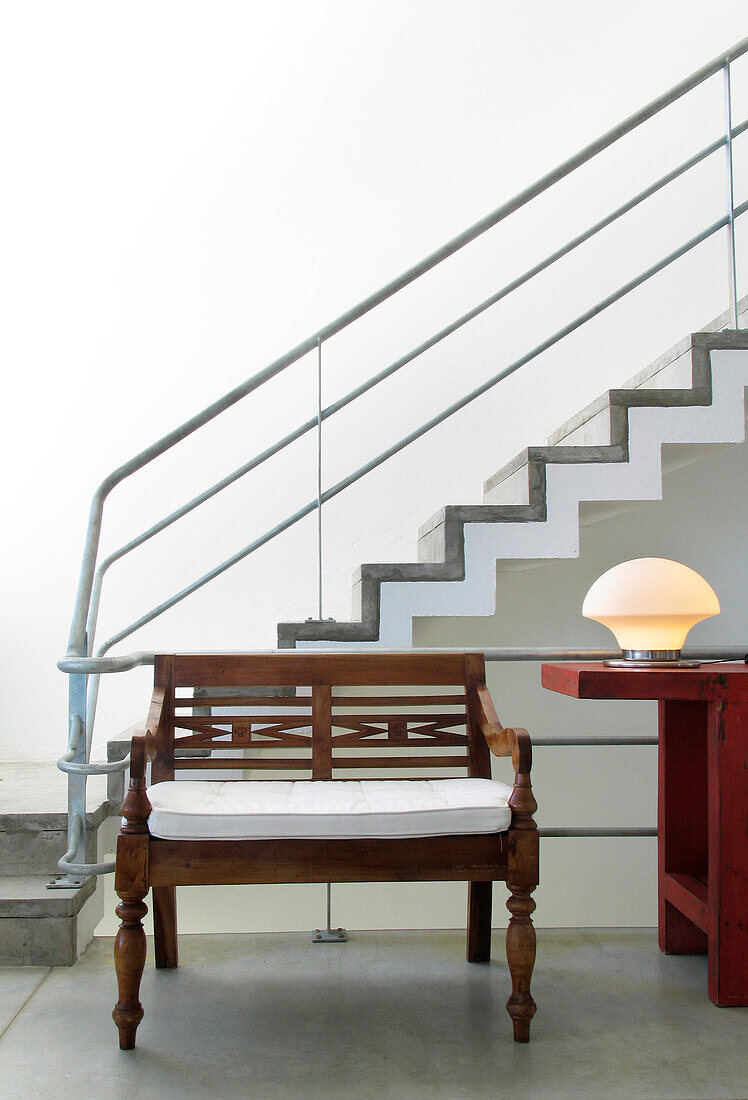 Ein Hocker und Beistelltisch aus Holz mit roter Patina und eine moderne Tischlampe