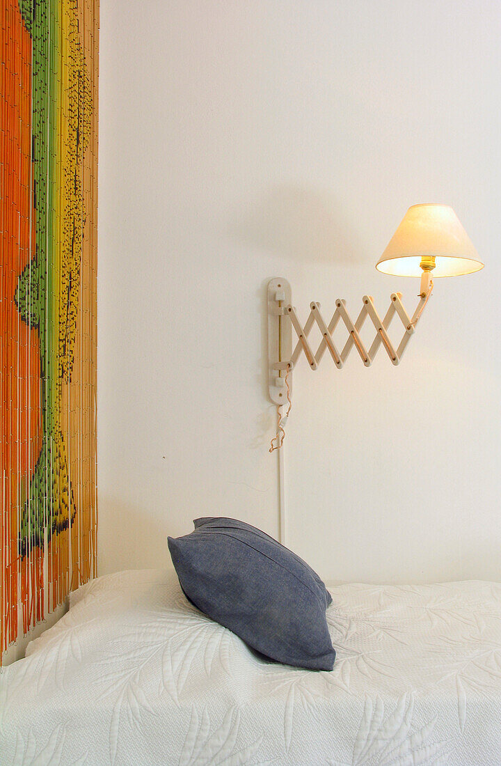 Bett mit Holzvorhang und Ziehharmonika-Lampe