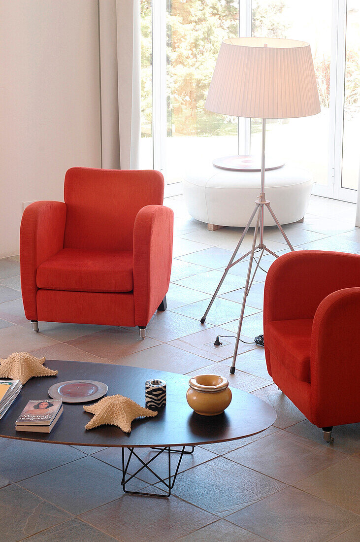 Passende rote Sessel in gefliestem Raum mit Stehlampe