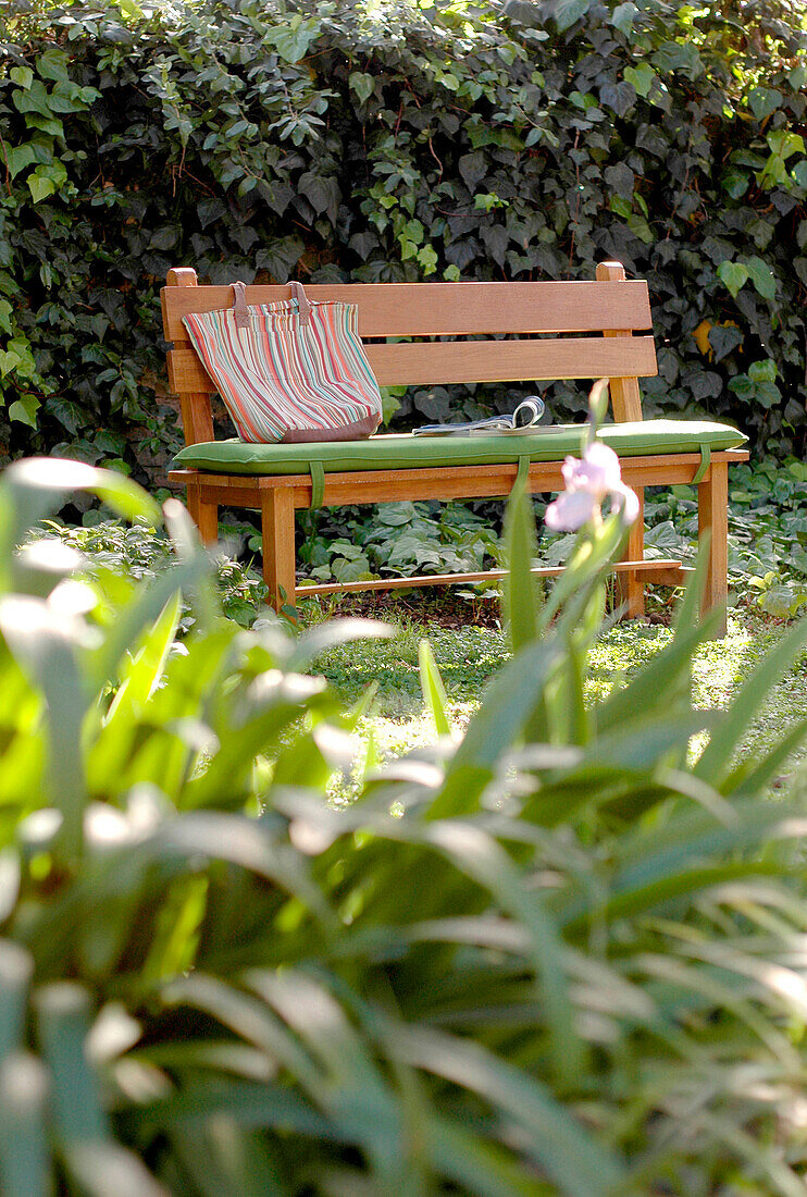 Bench seat with shopping bag in summer garden