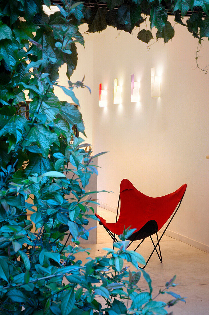 Roter Klappstuhl mit Kunstwerk in einem Galerieraum