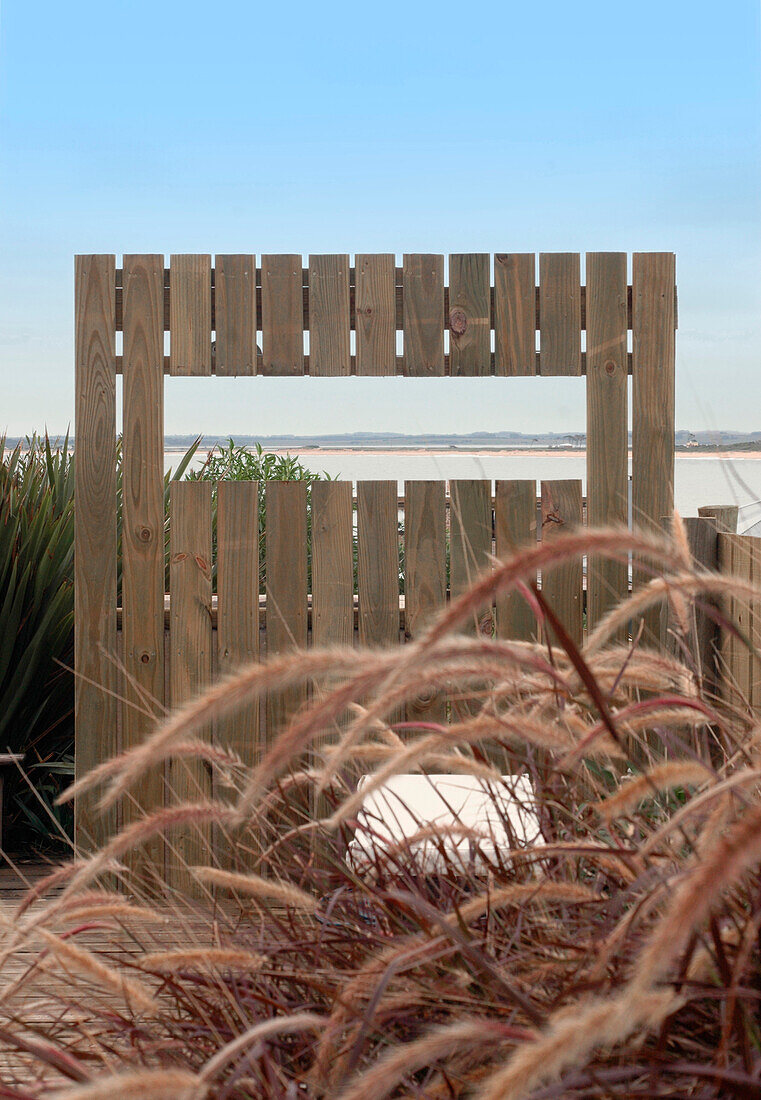 Gräser an der Küste und hölzerner Zaun am Eingang