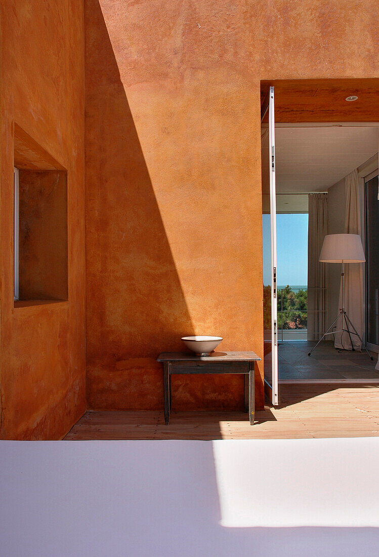 Strandhaus mit orangefarbener Fassade und offener Tür