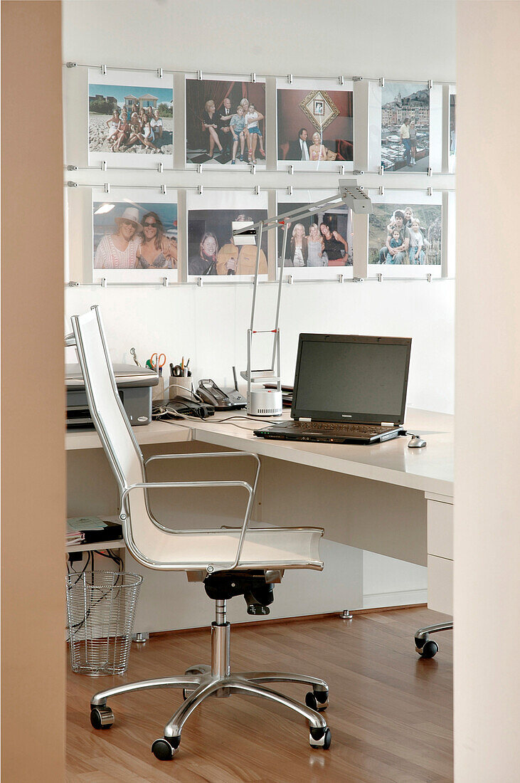 Weißes Arbeitszimmer mit Drehstuhl und Laptop