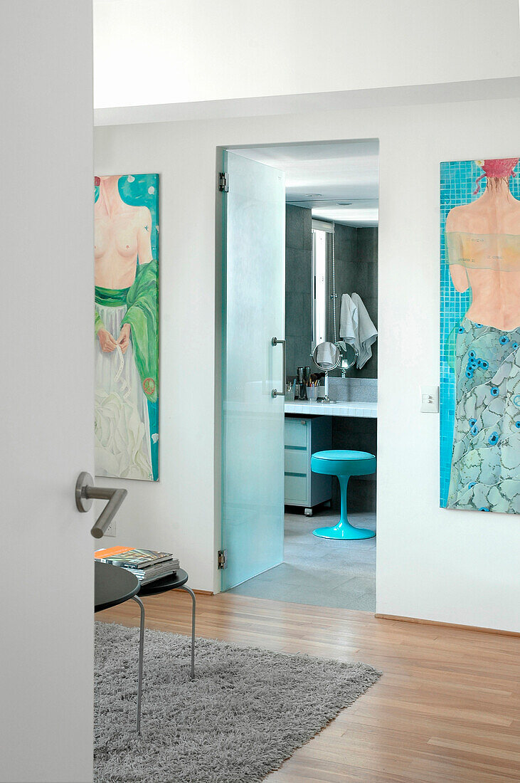 View from bedroom with modern artwork through door to en suite