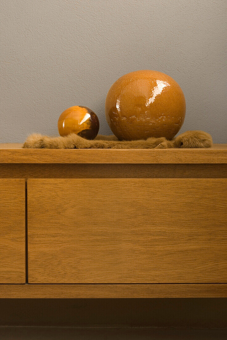 Two orbs on wooden sideboard