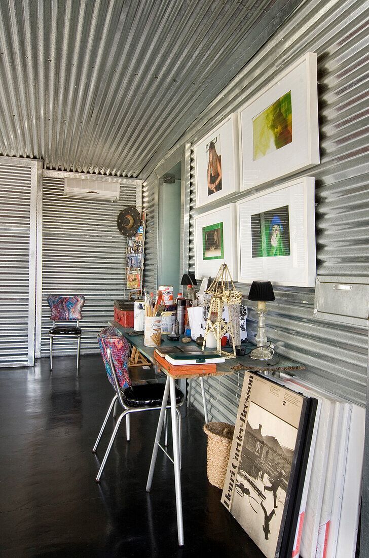 Galvanized metal room with artist's materials on work desk