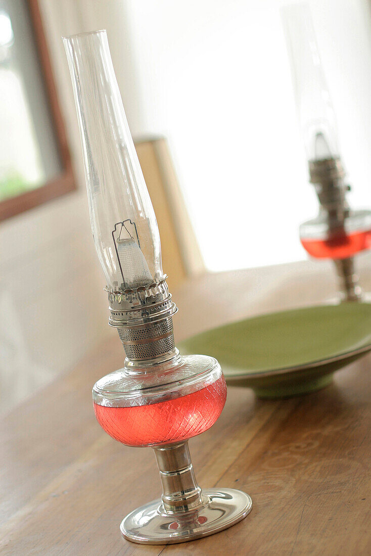 Rote Glas- und Metalllaternen auf einer Tischplatte mit Keramikschale