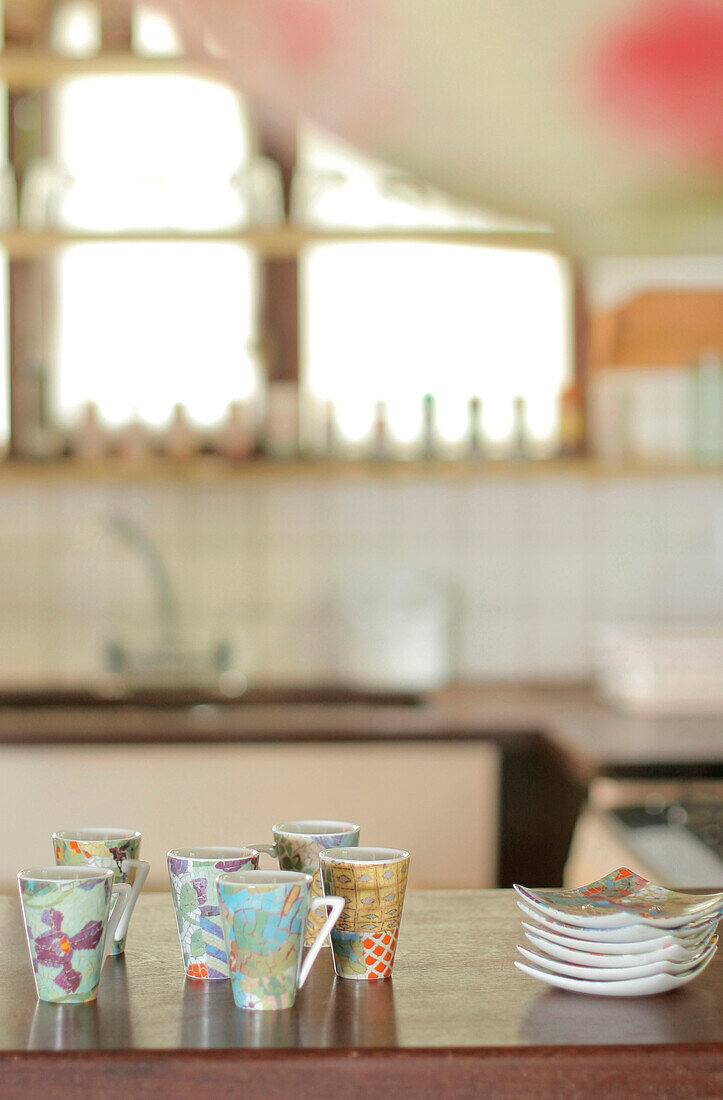 Handbemalte Tassen und Teller auf der Küchentheke