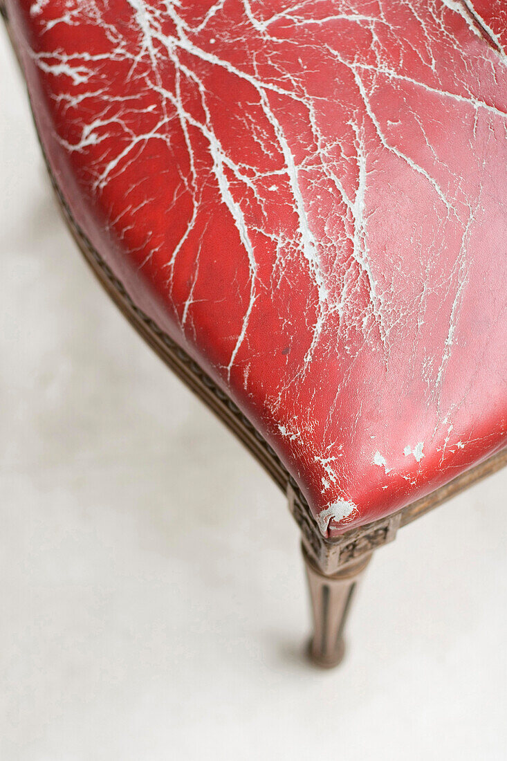 Distressed red leather upholstery on Louis XV chair