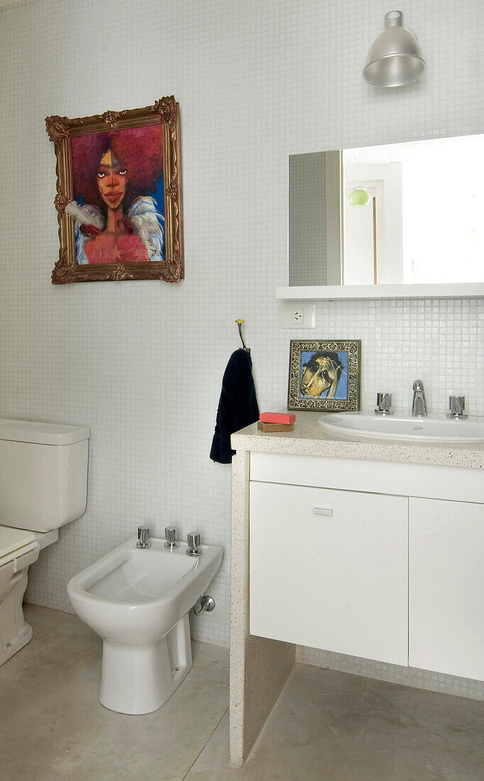 White ceramic wash stand and bidet in tiled bathroom