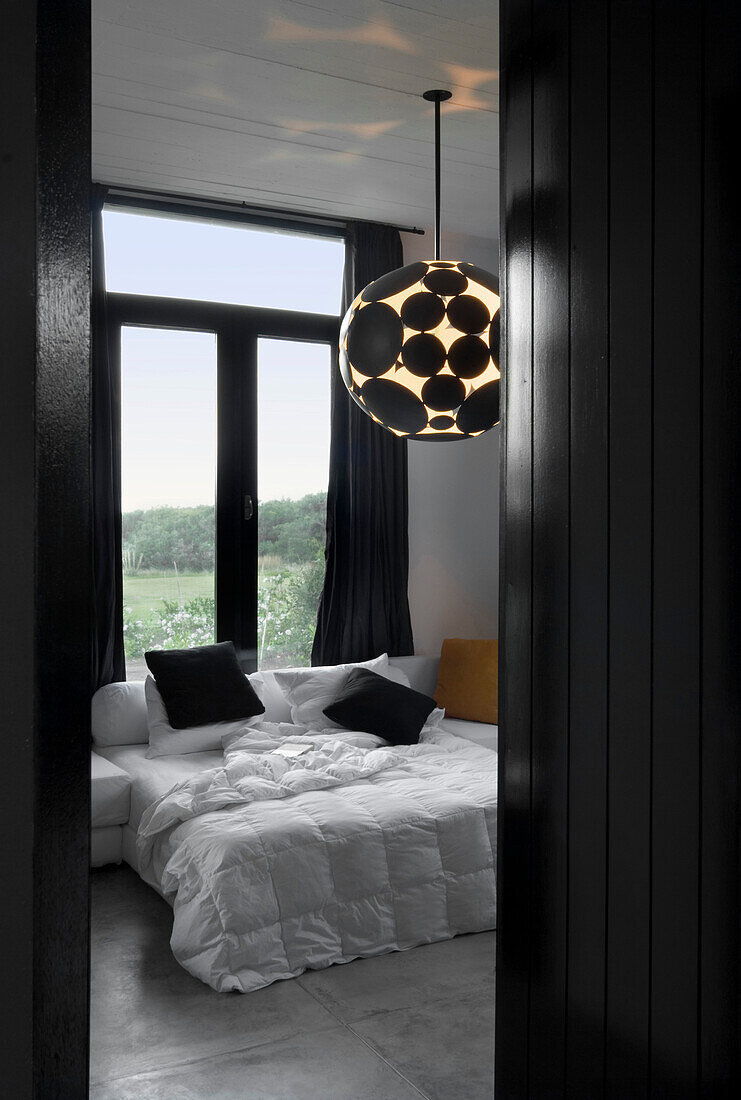Avantgardistische Deckenleuchte im kontrastreichen schwarz-weißen Schlafzimmer