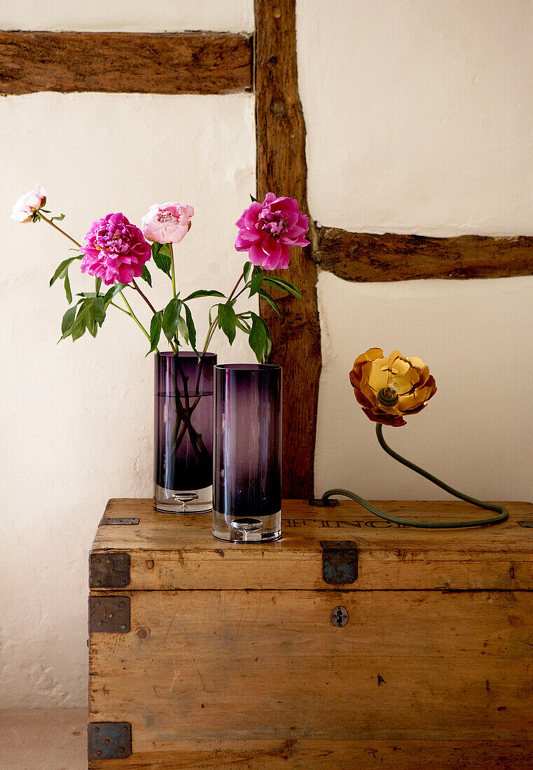 Cut flowers ain vases on travelling chest in timber framed 17th Century Oxfordshire house