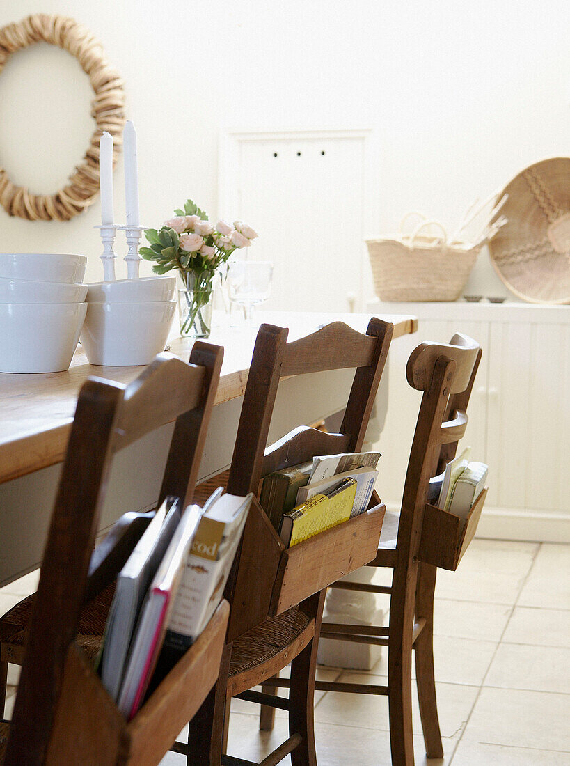 Wooden chairs with books in sunlit kitchen