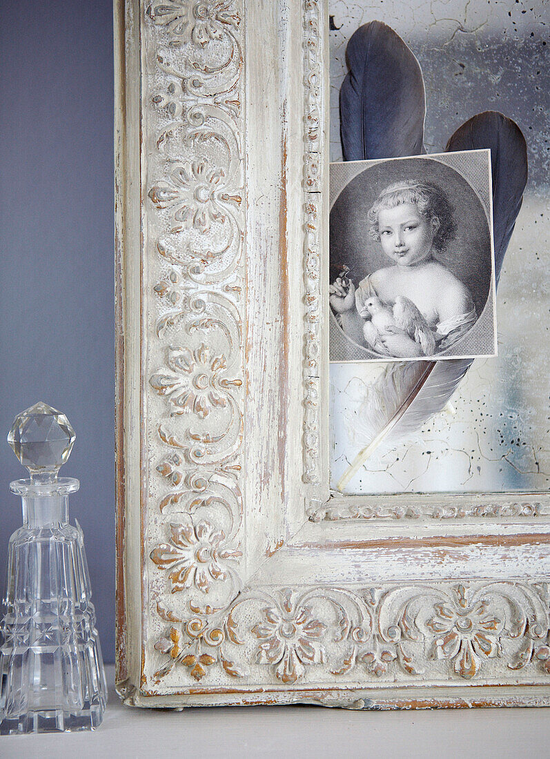Ecke des geschnitzten Bilderrahmens mit Glaskaraffe und schwarz-weißem Porträtbild