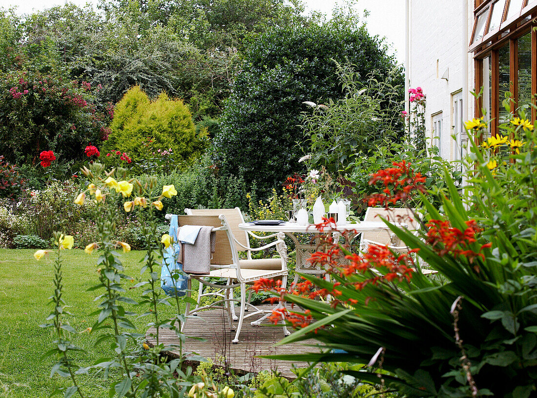 Gartenmöbel auf einer Terrasse mit blühenden Blumen