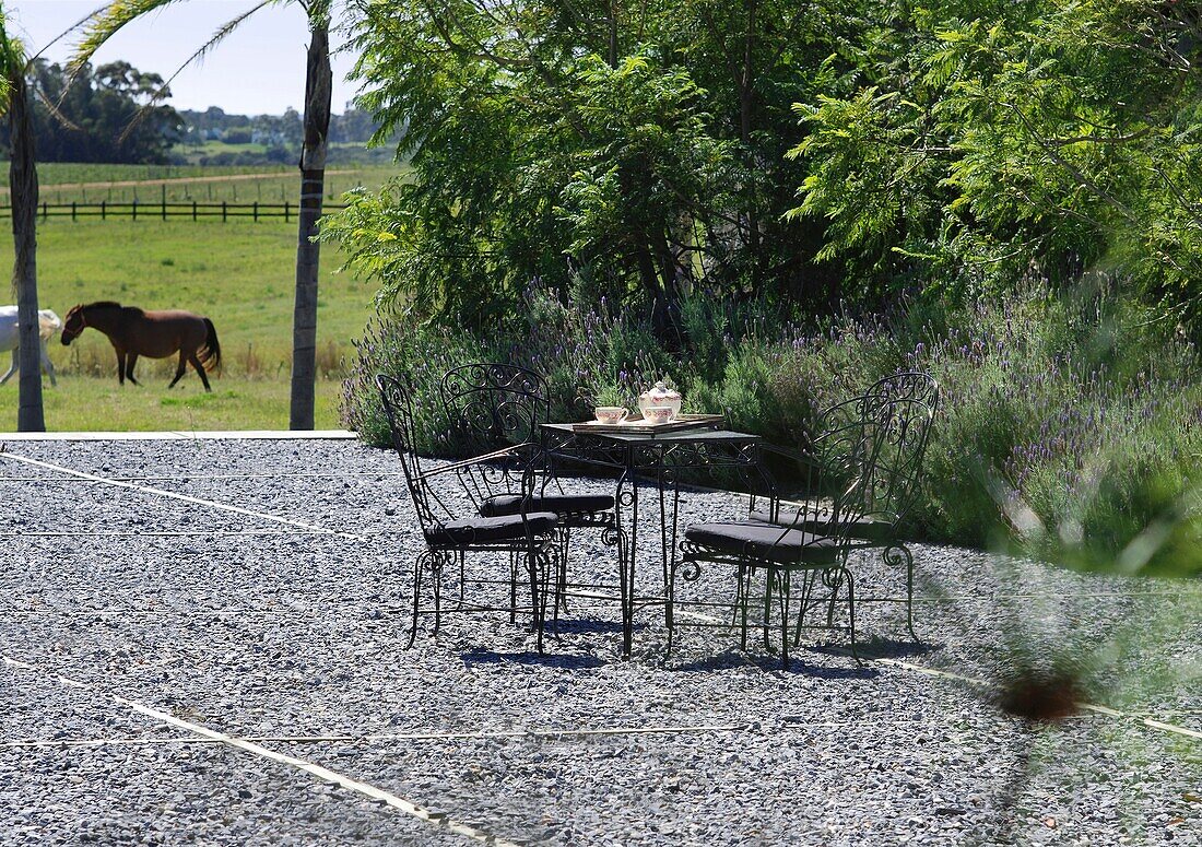 Tisch und Stühle im Freien im Hinterhof eines modernen Bauernhauses in Uruguay