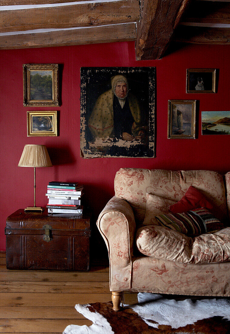 Balkendecke und dunkelrote Wände über dem Sofa im Wohnzimmer in Oxfordshire aus dem 17. Jh.