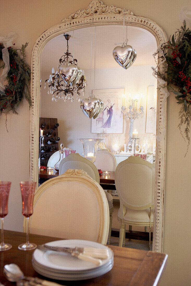 Heart shaped silver decorations hang from painted dining room mirror