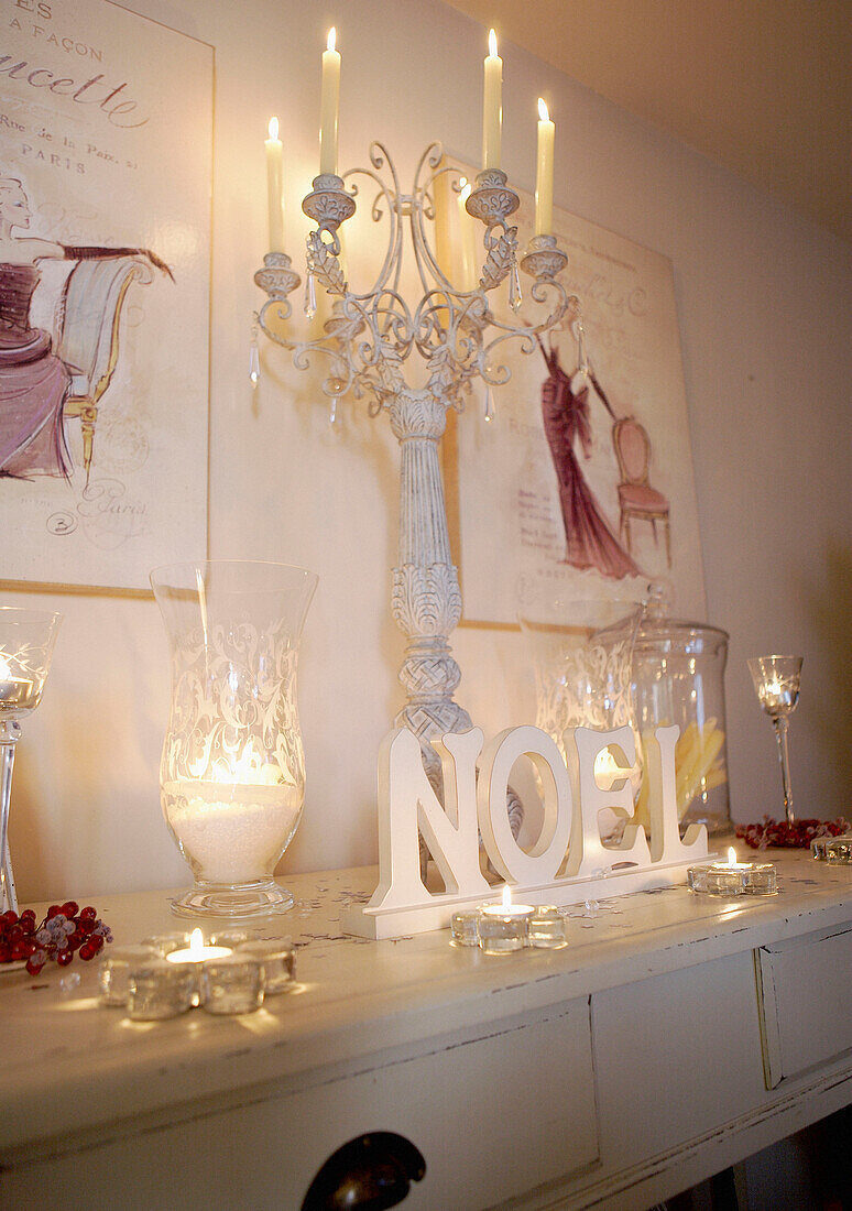 Kerzen und Kunstwerke mit Kristallgläsern auf einem bemalten Konsolentisch