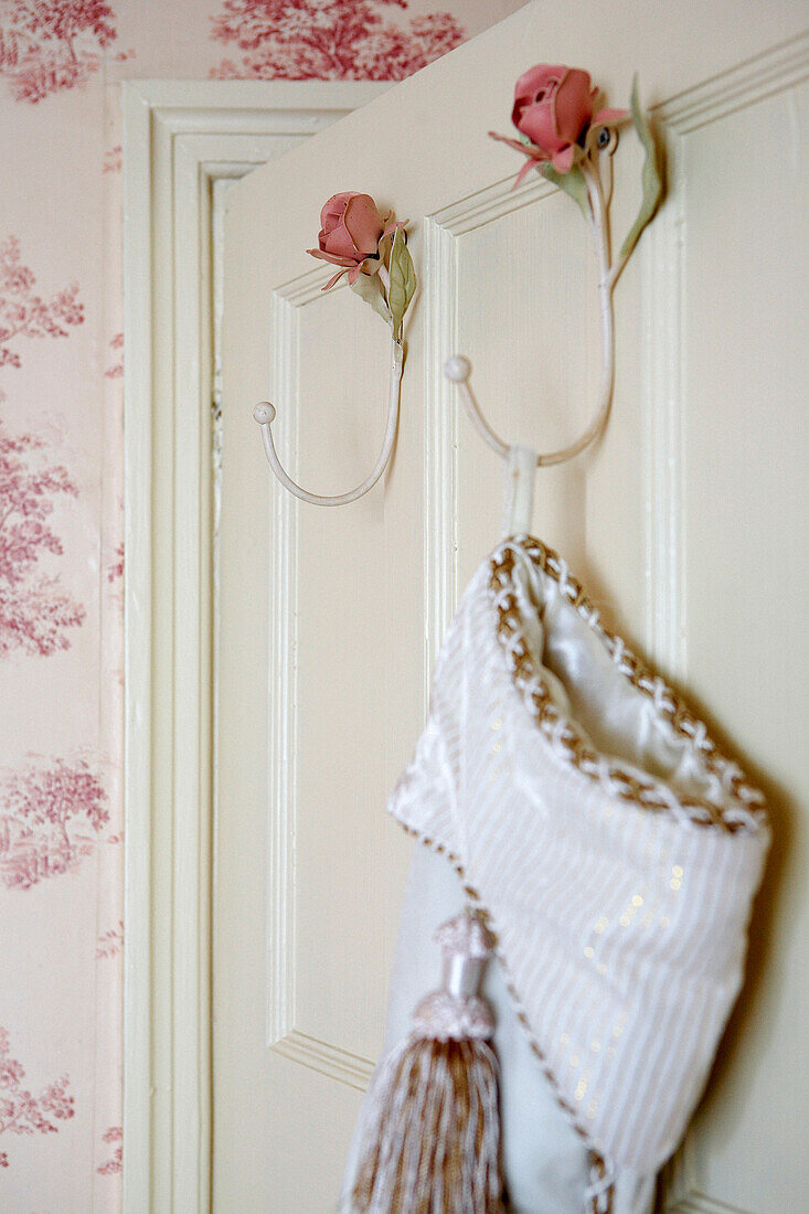 Waschbeutel hängt an rosenförmigen Haken an der Rückseite der Schlafzimmertür