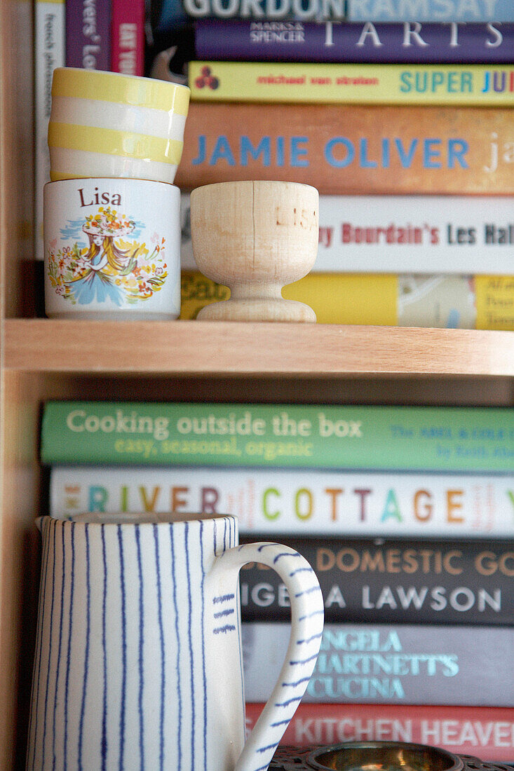 Eggcups and striped milkjug on bookcase