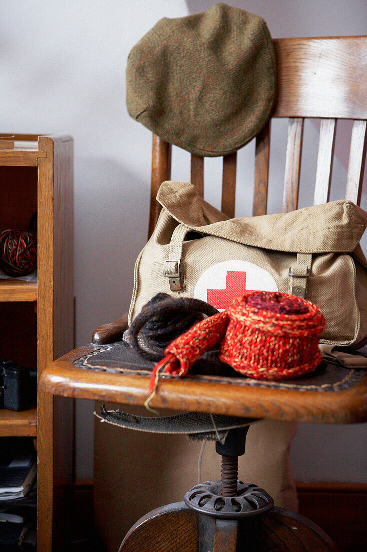 Cloth cap and satchel on wooden swivel chair