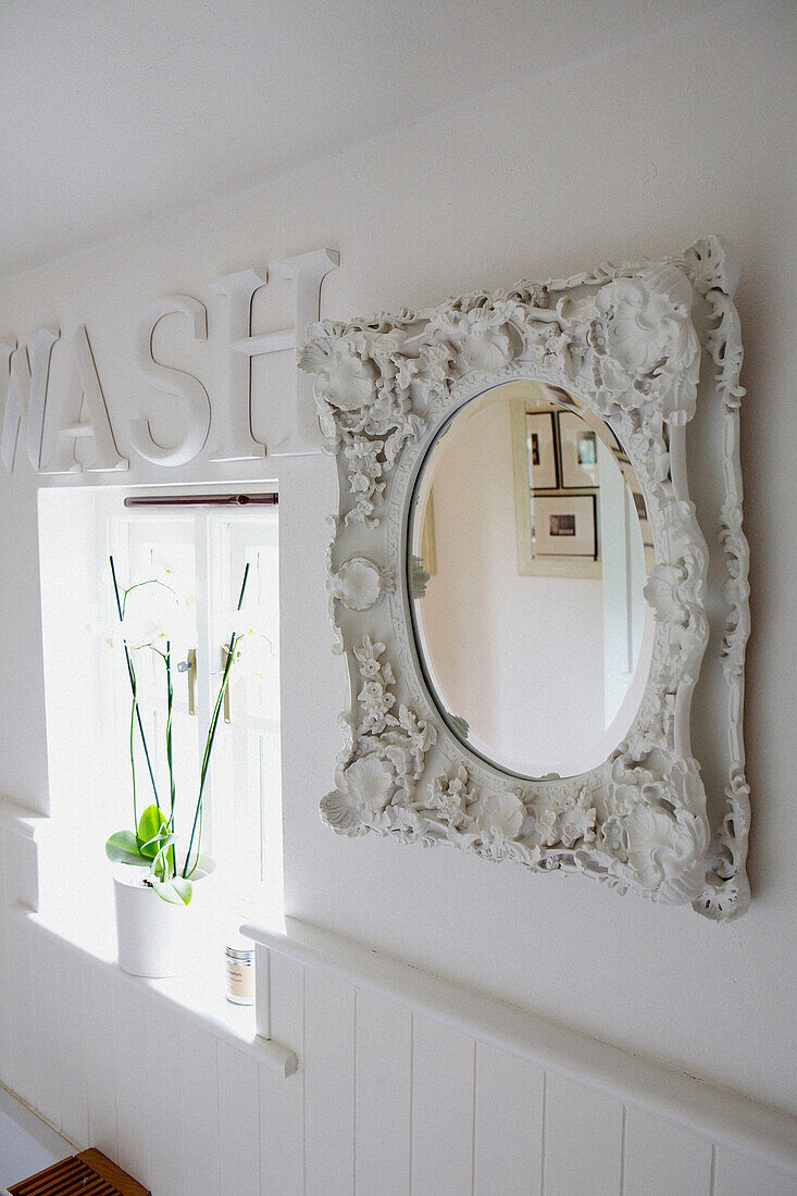 Badezimmerfenster mit kunstvoll bemaltem weißen Spiegel und Wash-Schriftzug an der Wand