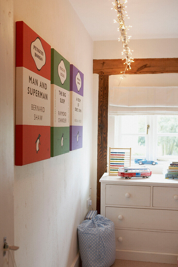 Bunte Pinguin-Bucheinbände an der Wand im Kinderzimmer