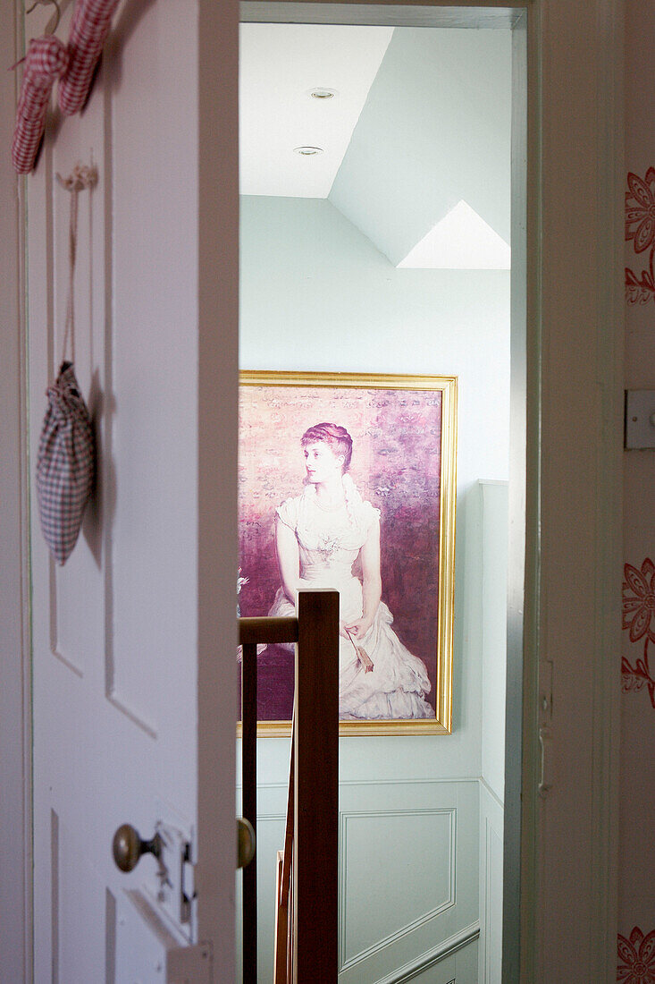Open bedroom doorway to portrait on hallway staircase