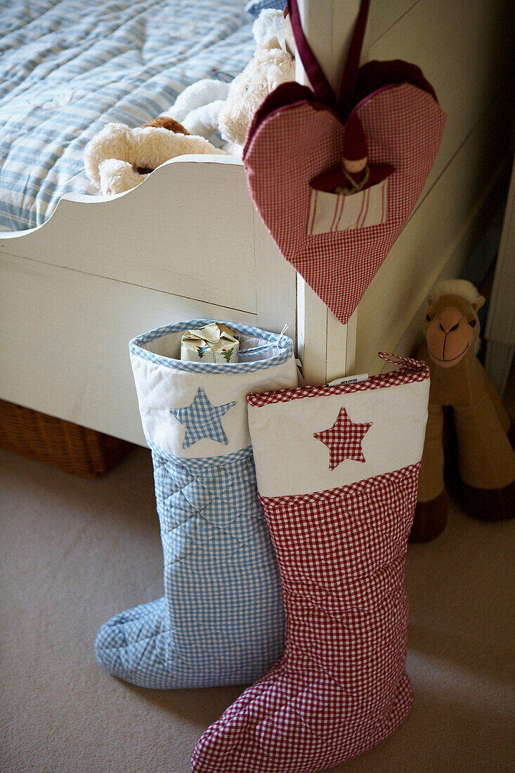 Christmas stockings in gingham check at foot of child's bed