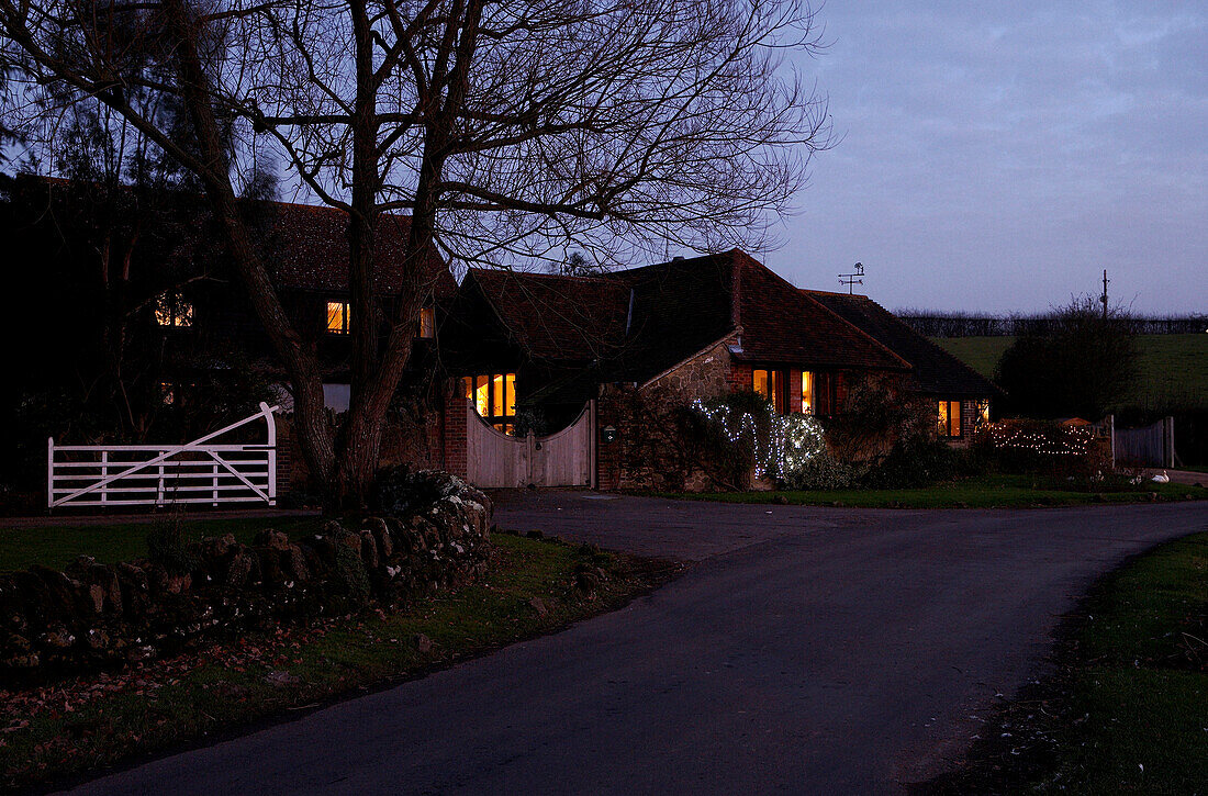 Lit lights on of country house exterior at dusk