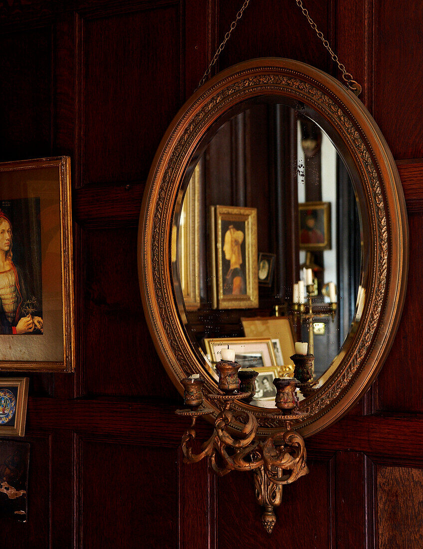Gilded girandole mirror reflecting artwork in Grade I listed Elizabethan manor house in Kent