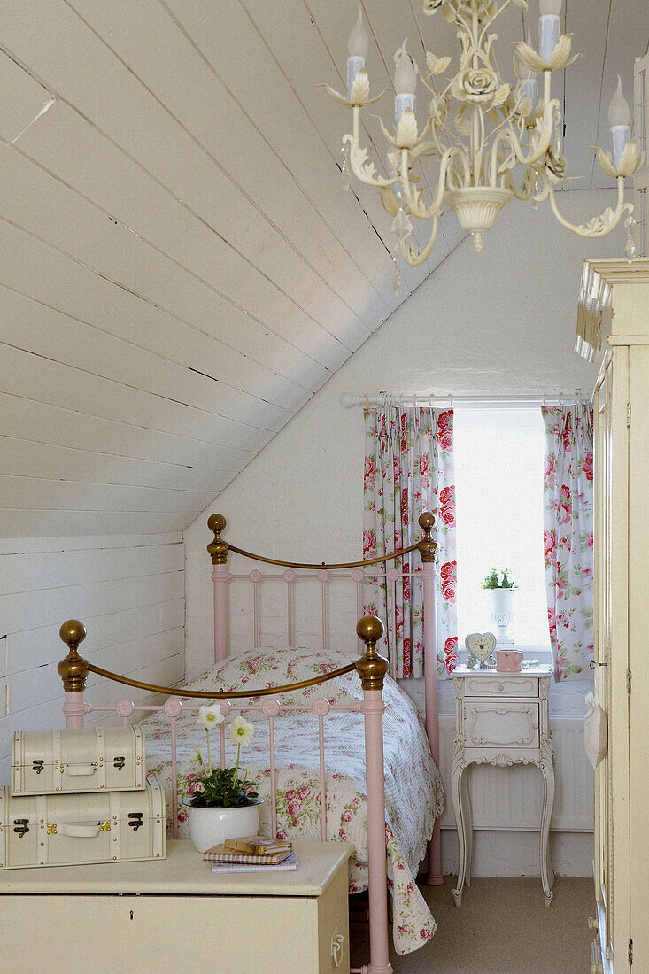 Single bed with brass bed knobs in attic bedroom with co-ordinating curtains and bedspread
