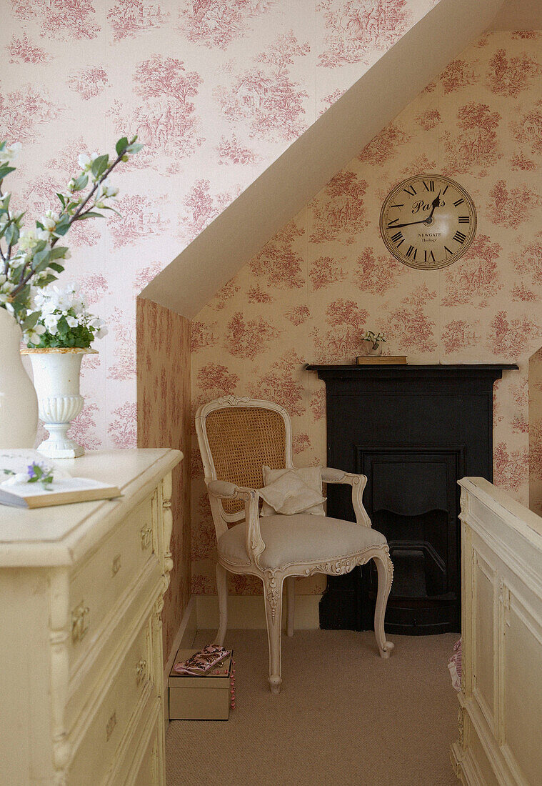 Bedroom with floral wallpaper and original fireplace with clock 