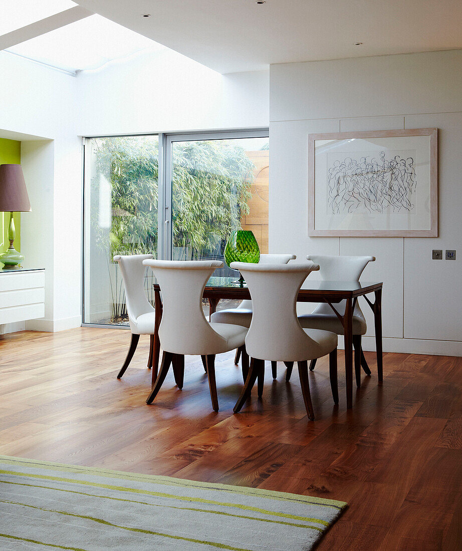 Dining room table and chairs with artwork in open plan apartment 