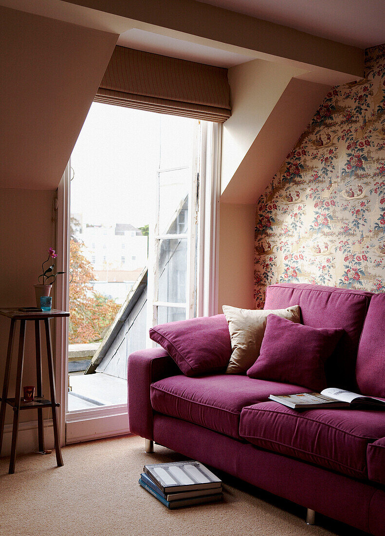 Fuchsia sofa in living room with open doors to roof terrace in a Georgian townhouse