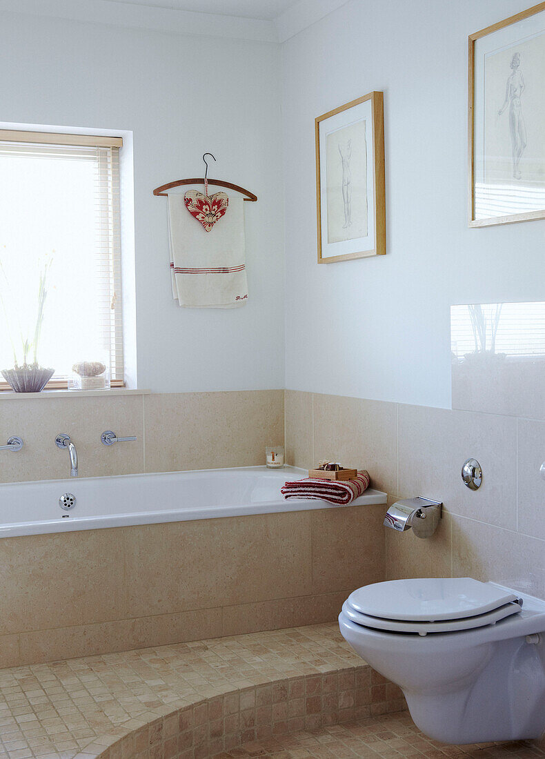 Cream tiled bathroom with sunlit window