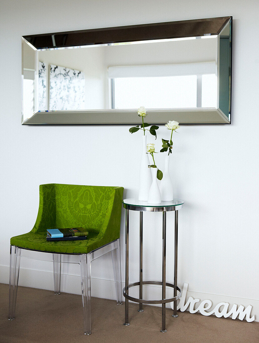 Lime green chair and metal framed side table below mirror