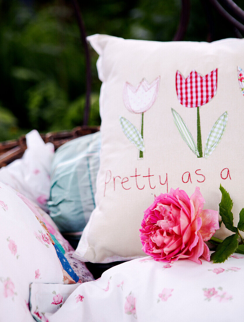 Personalised cushions with single rose in garden