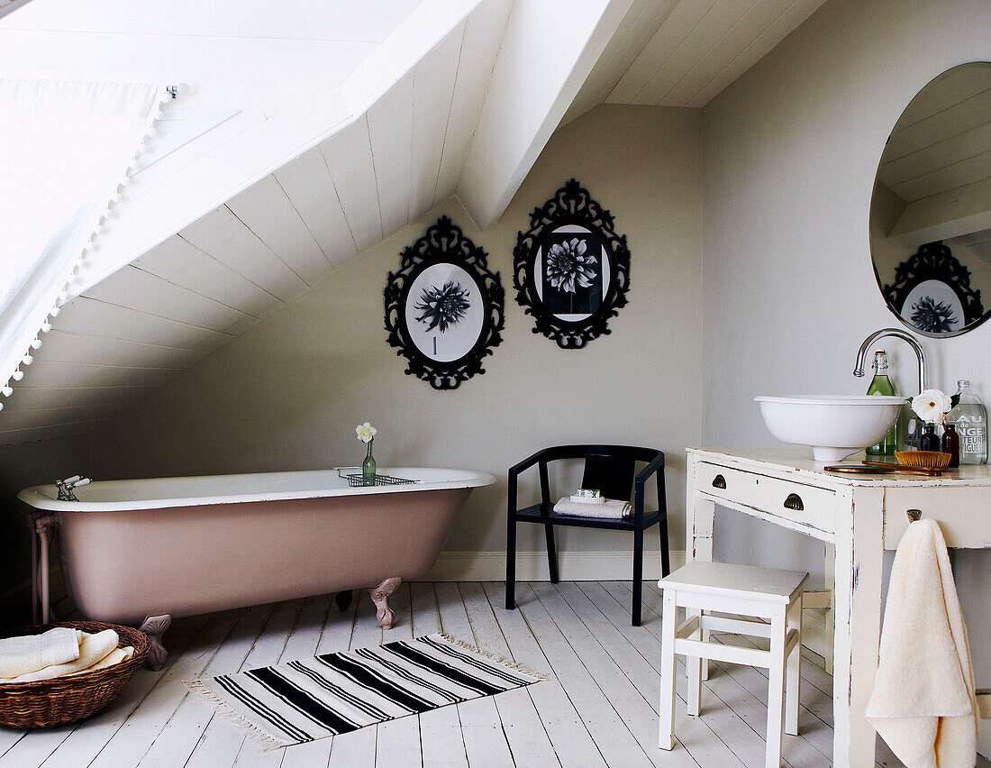 Badezimmer im Dachgeschoss mit Bilderrahmen aus Metall und schräger Decke
