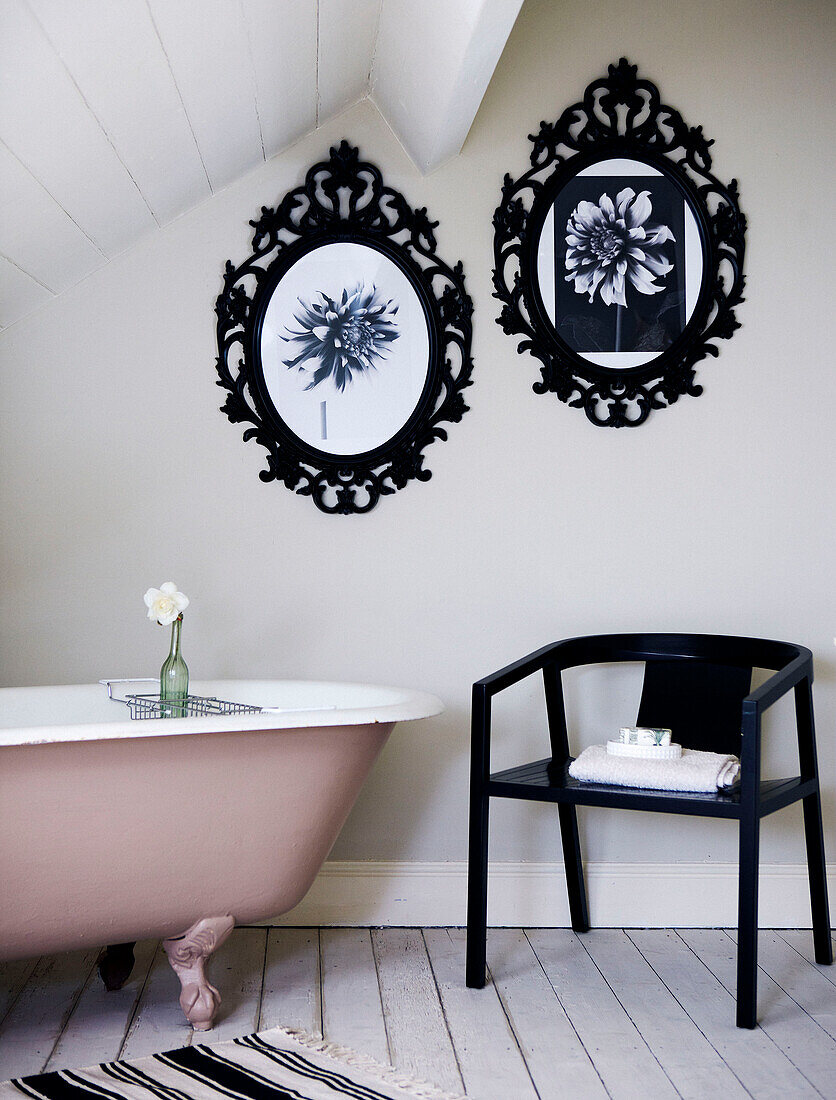 Badezimmer im Dachgeschoss mit Bilderrahmen aus Metall und freistehender rosa Badewanne