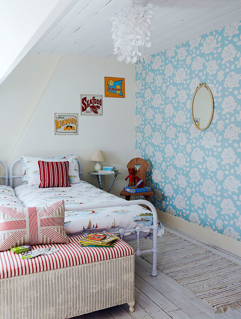 Child's room with floral patterned wallpaper and metal framed twin beds