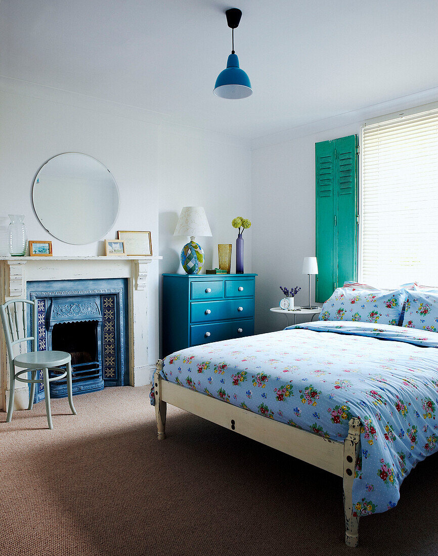 Floral gemusterte Bettdecke im Schlafzimmer mit blauen und türkisfarbenen Armaturen