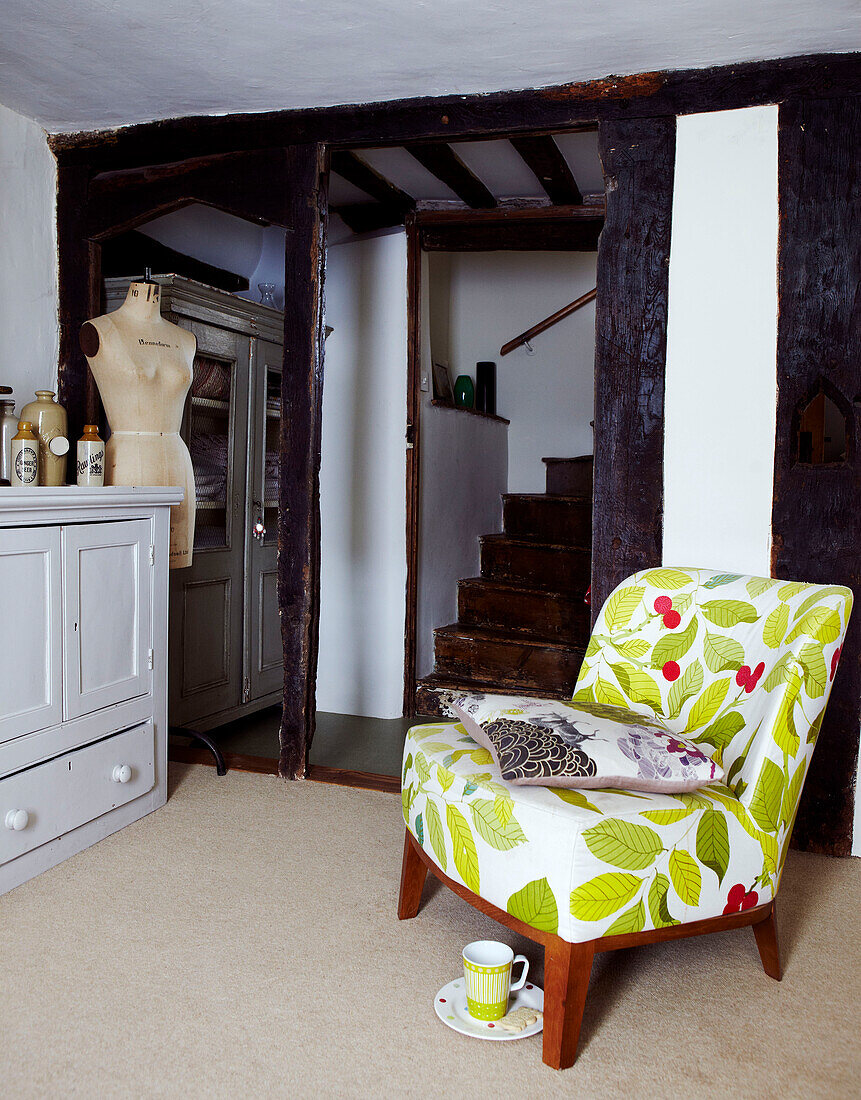 Sessel mit Blumendruck im Treppenhaus eines Cottage in Devon