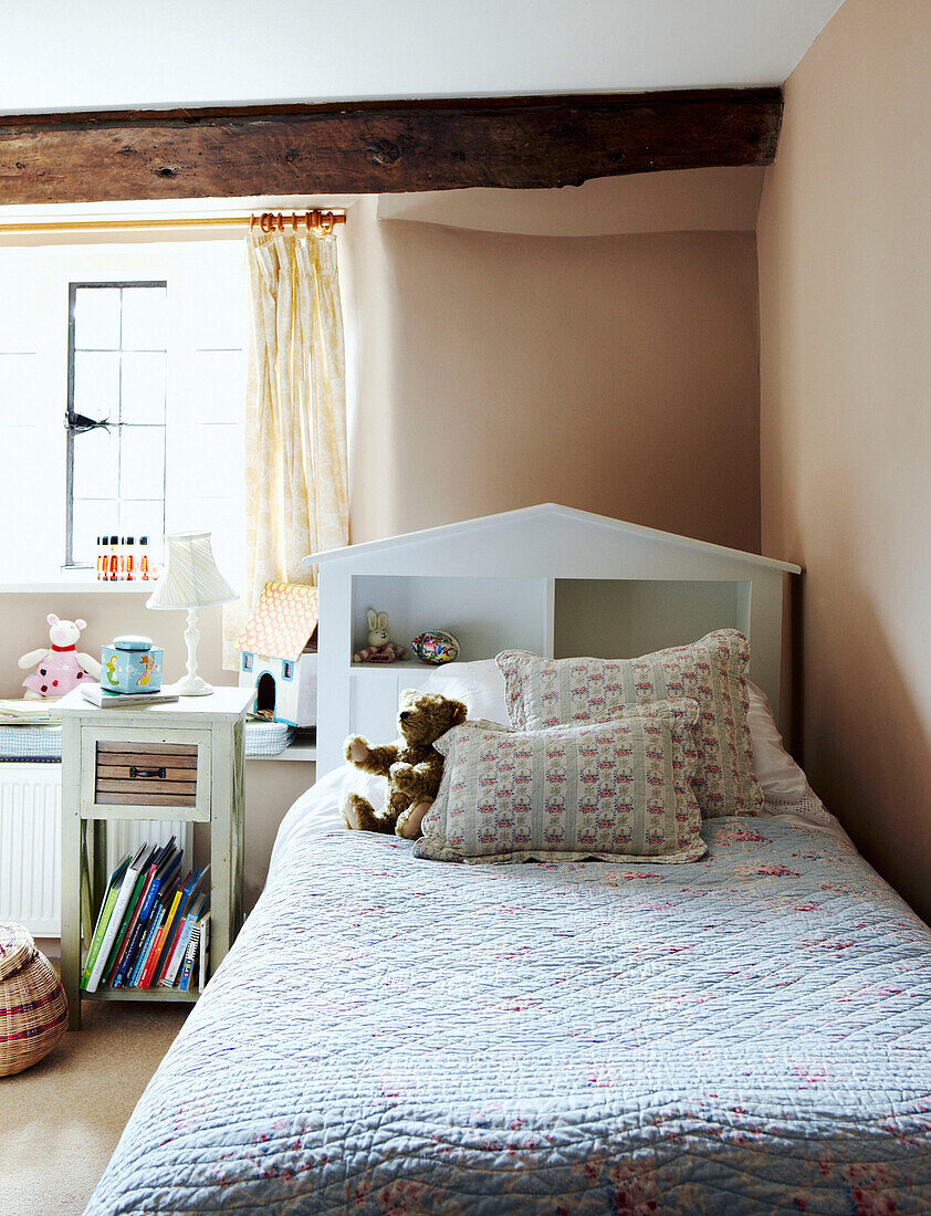 Teddybear on quilted bedspread in Devon cottage