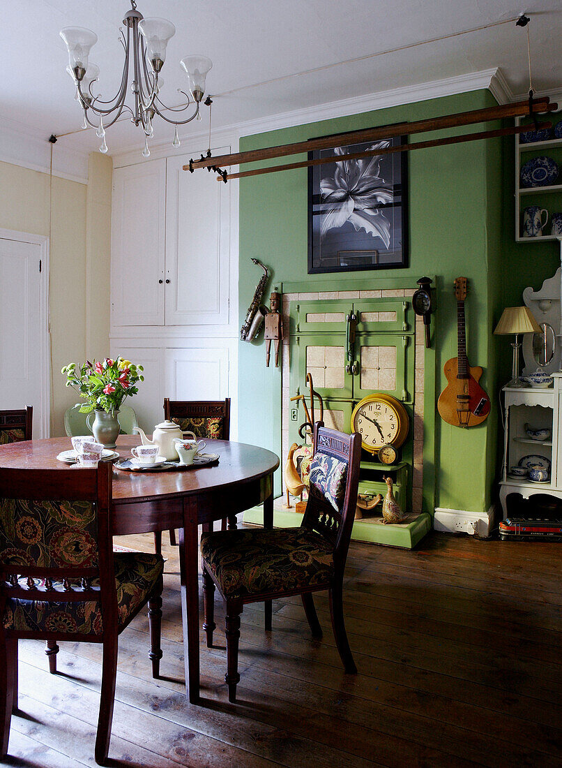 Esszimmer mit rundem Tisch und grüner Wand und Leisten