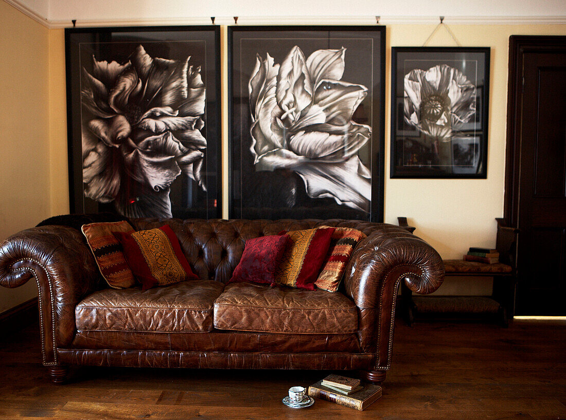 Vintage leather sofa with botanical drawings on wall behind